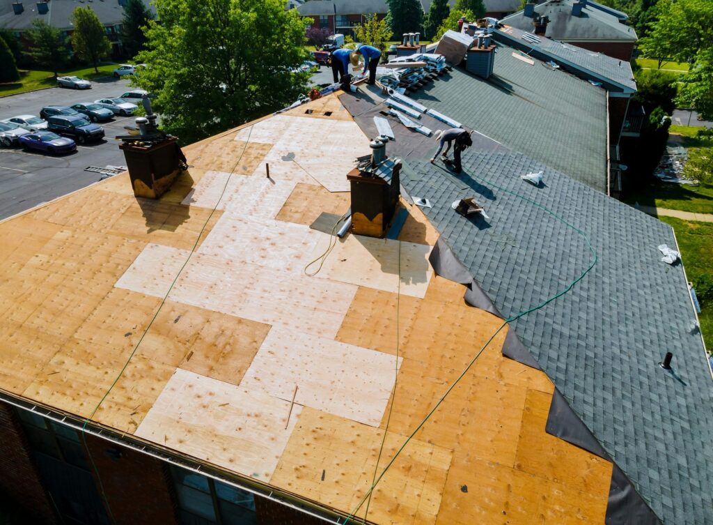 RM Roofing | roof repairs old roof replacement with new shingles of an apartment building
