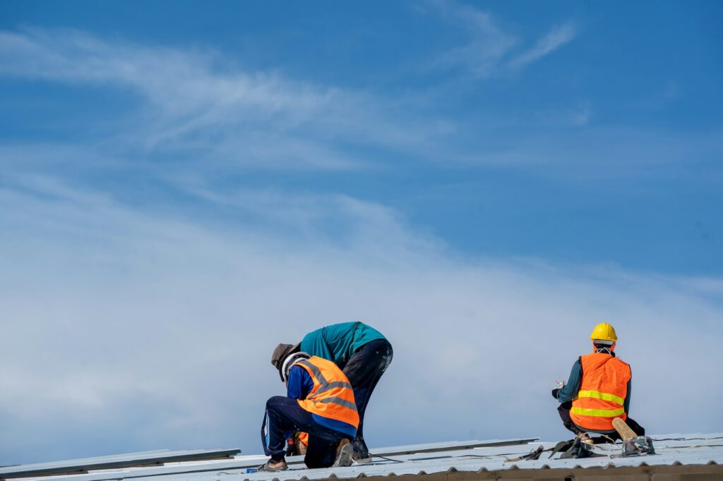 RM Roofing | roofer working at metal profile roof installation roofing tools electric drill used on new roofs