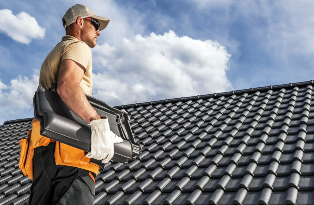 RM Roofing | roofing worker with a ceramic roof tiles in his hands