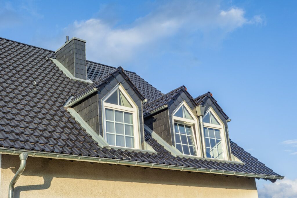 RM Roofing | dormers on the grey slate roof with the sky in the background